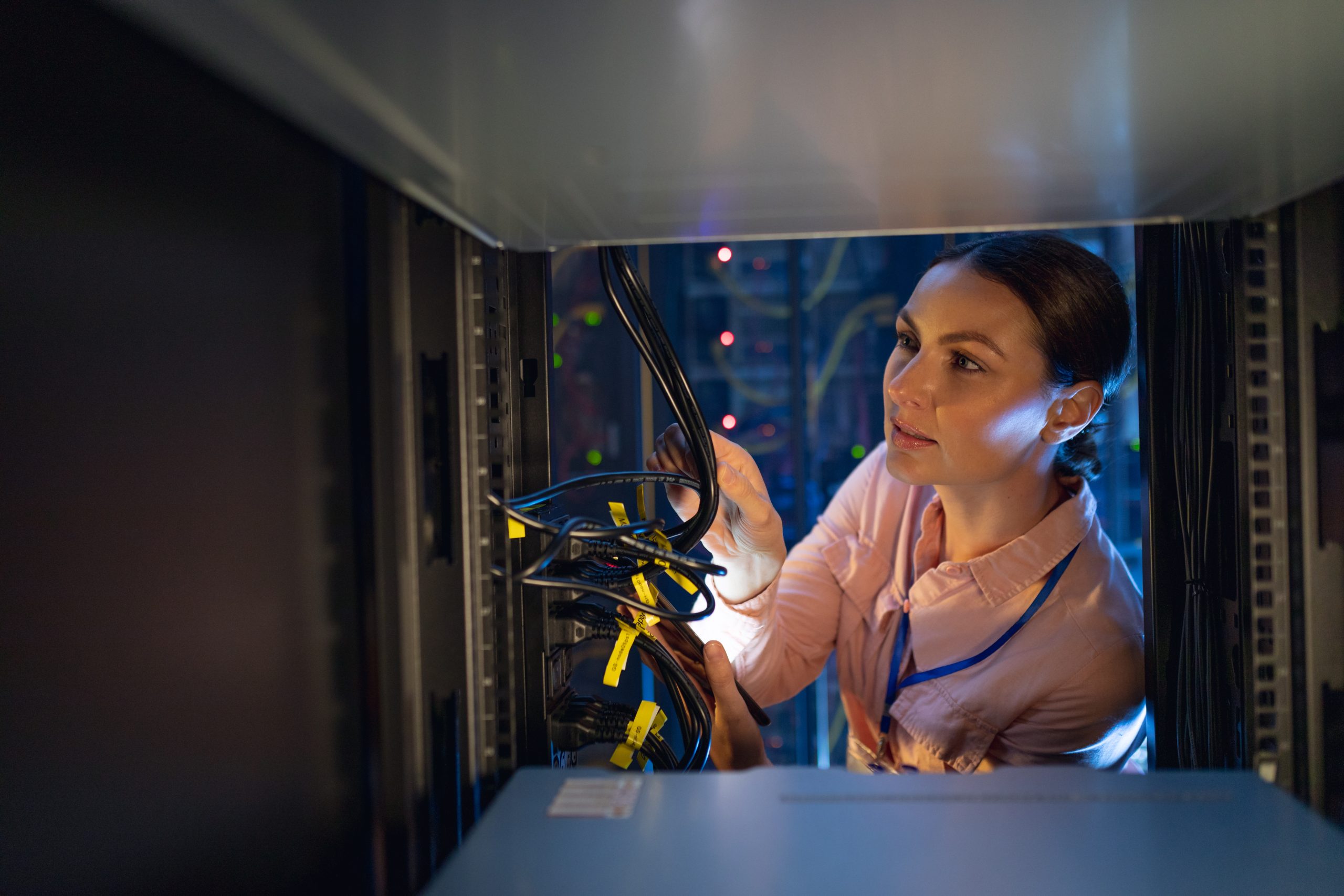 Caucasian female engineer inspecting the server in computer server room. database server management and maintenance concept