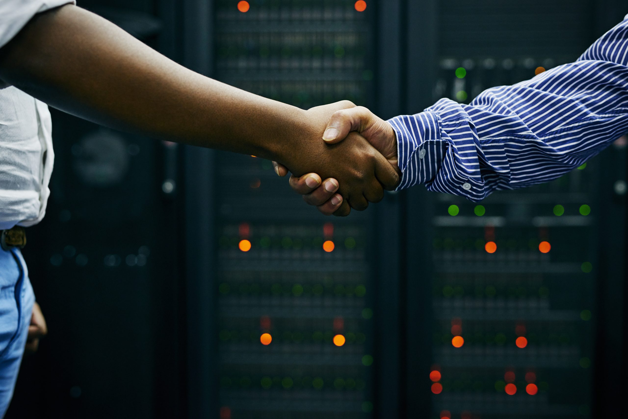 Paired up for professional IT service. Cropped shot of two men shaking hands in a data center